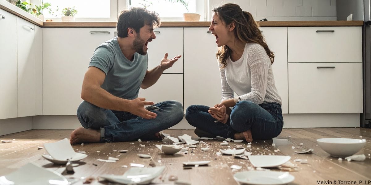 A married couple sitting apart, tense, during a difficult year of marriage