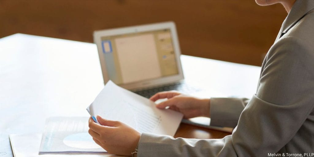 Woman reviewing financial documents after suspecting husband wants a divorce